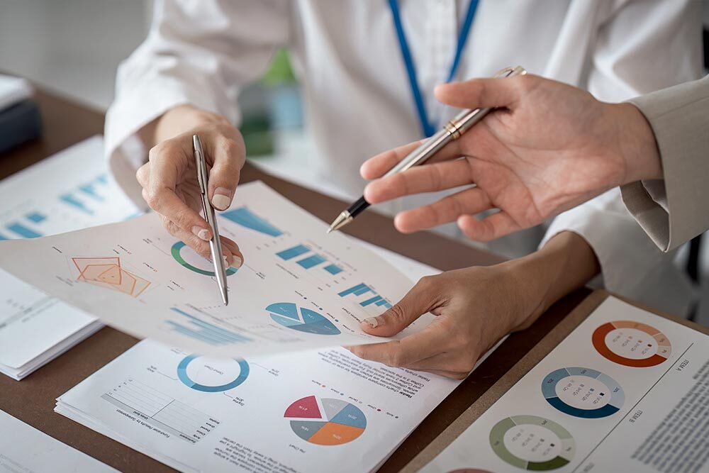 people reviewing statistics as printed charts and graphs